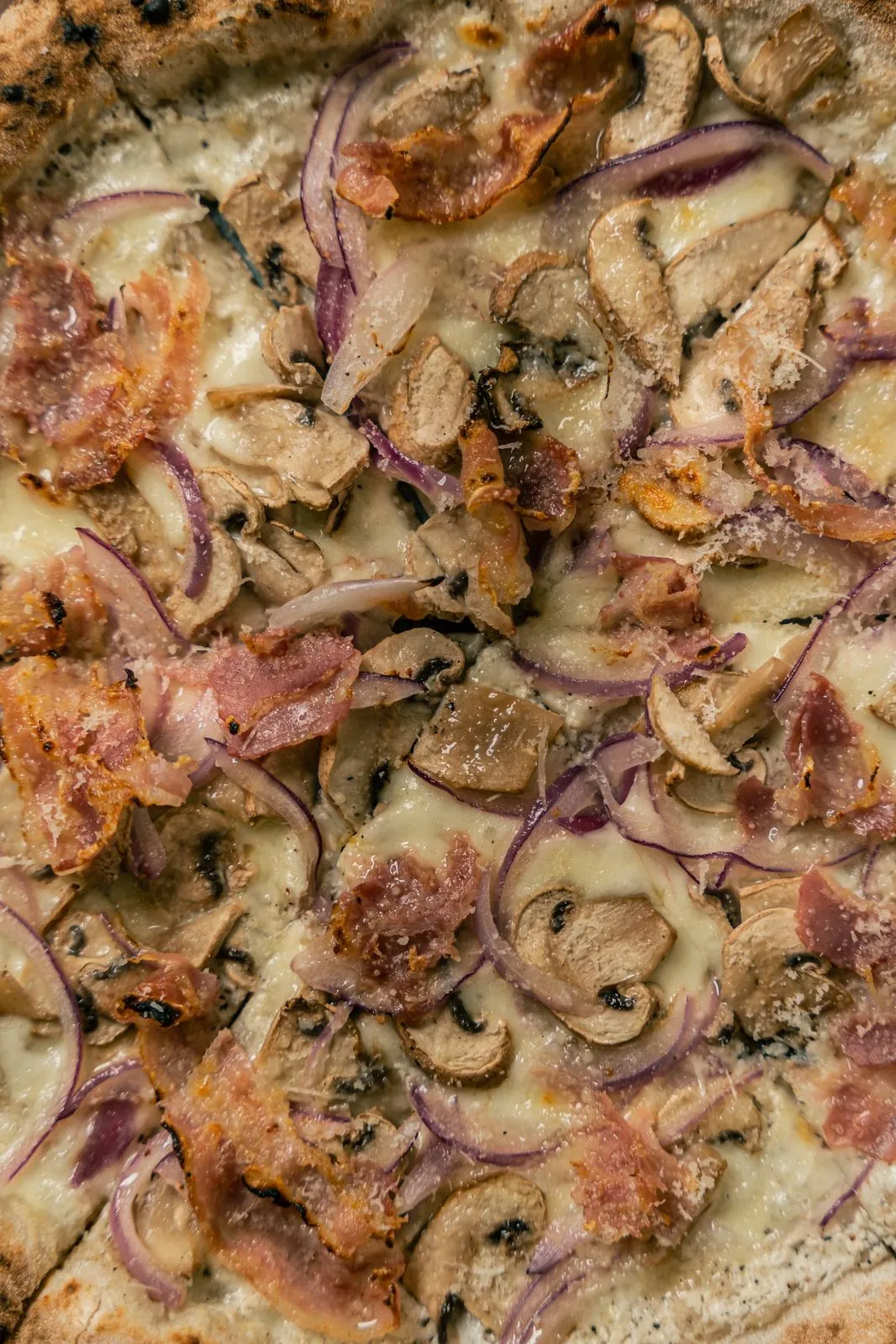 Detalle de pizza con champiñón y cebolla morada