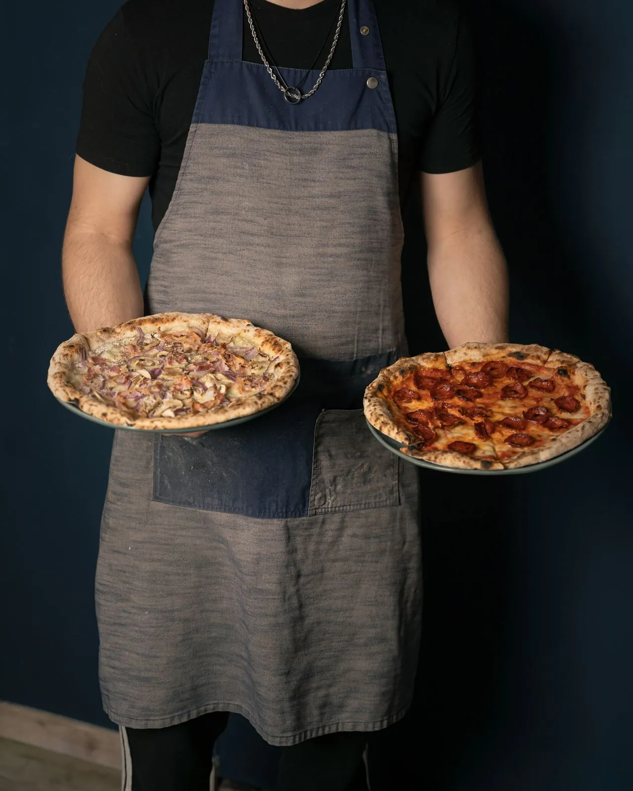 Camarero con dos pizzas recién salidas del horno