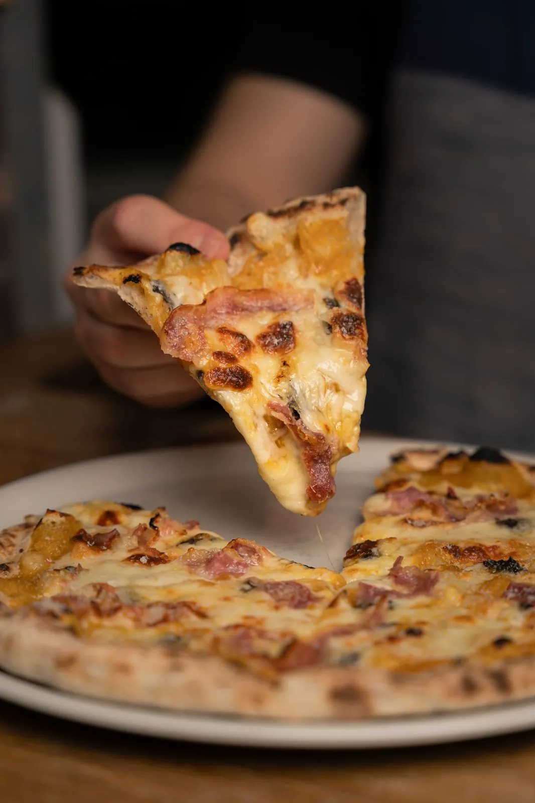 Porción de pizza Mitoa con hilo de queso fundido