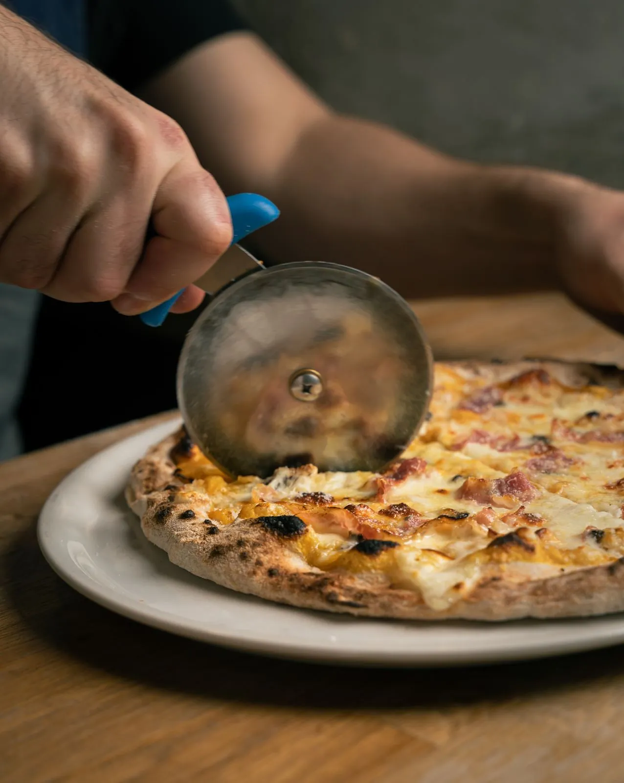 Cortando una pizza recién salida del horno